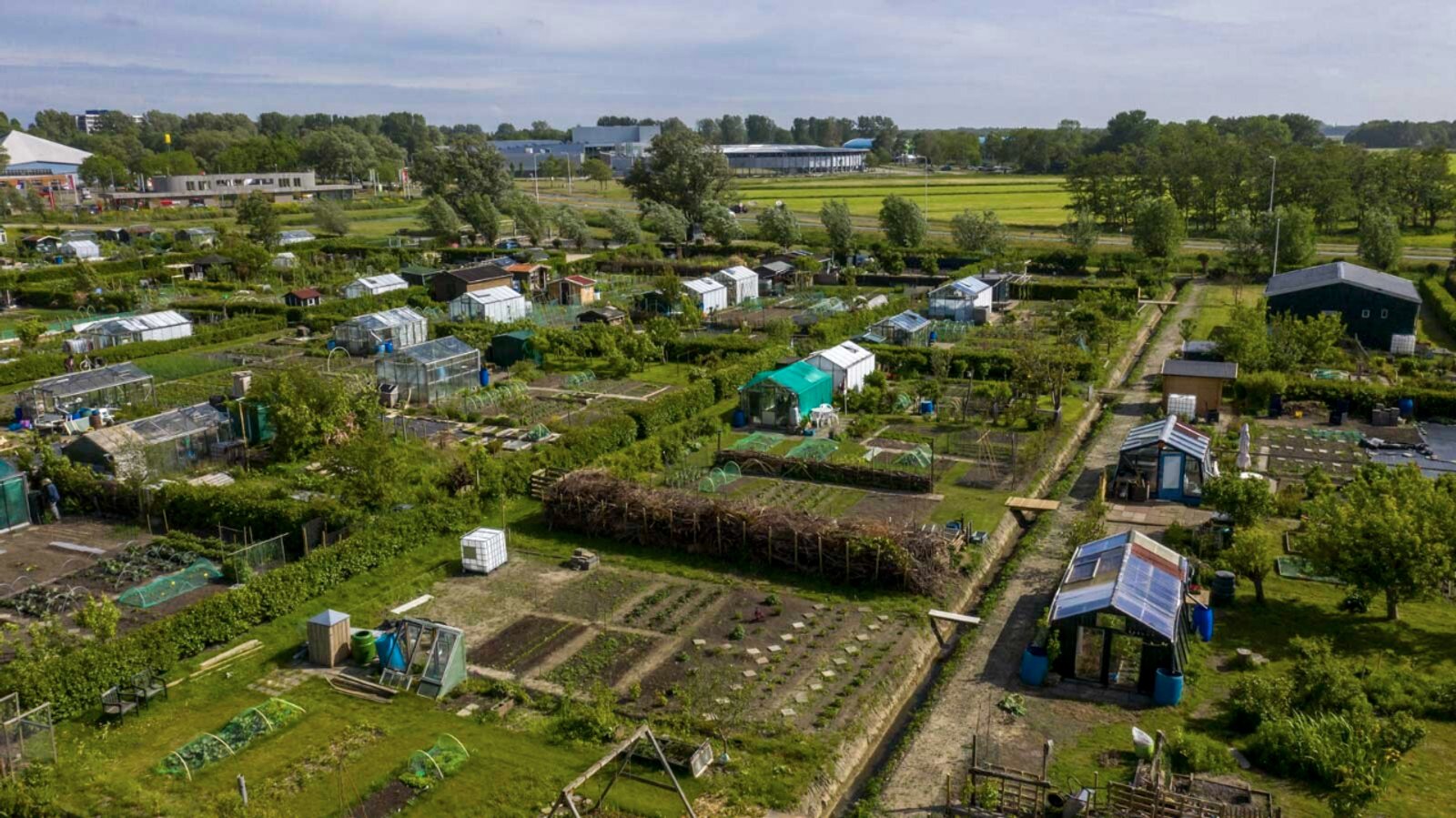 Overzicht van de moestuinen, kassen en groene paden van De Meerweg